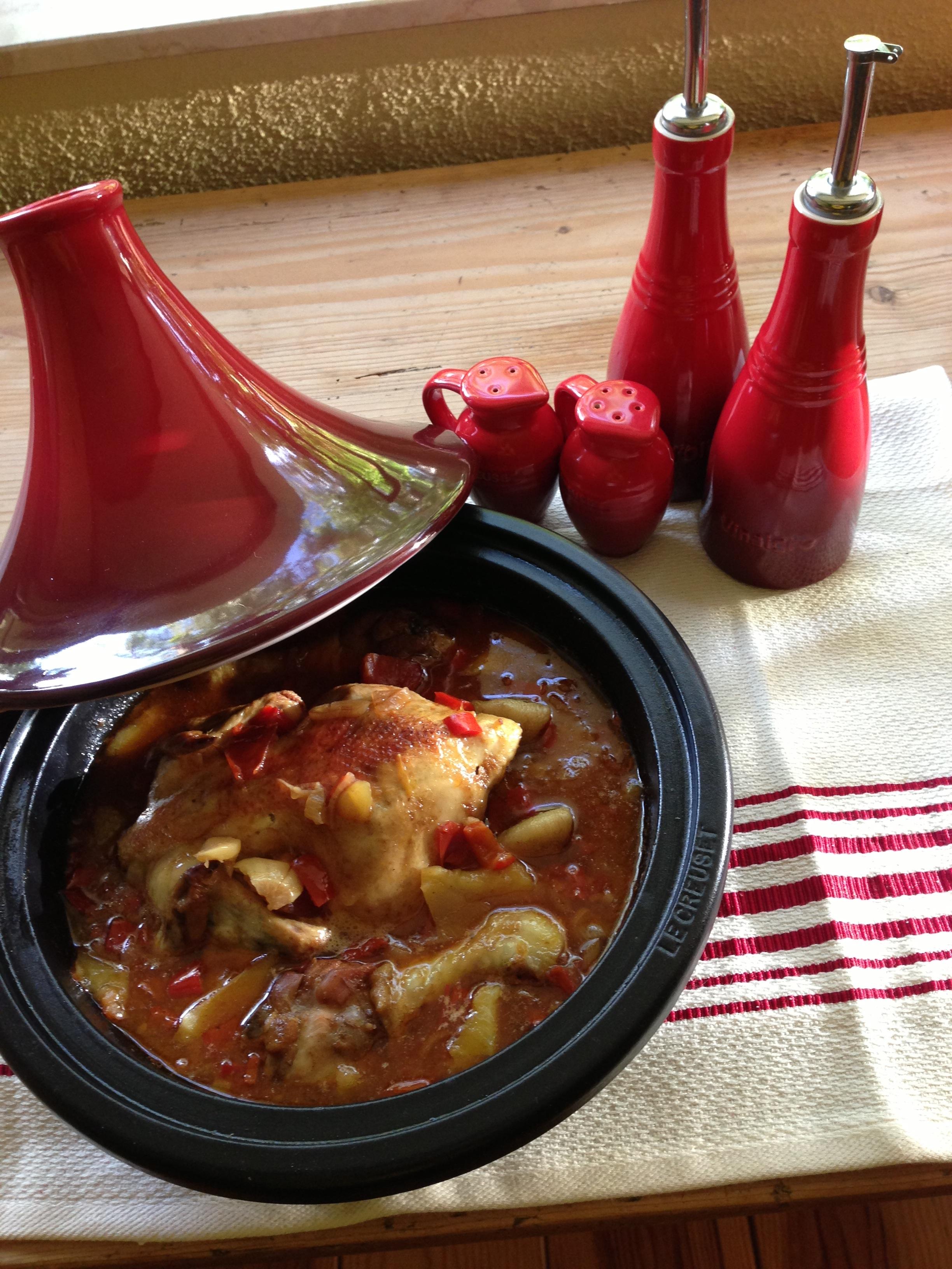 Tajine gevuld met poussin omgeven door zoet en pit