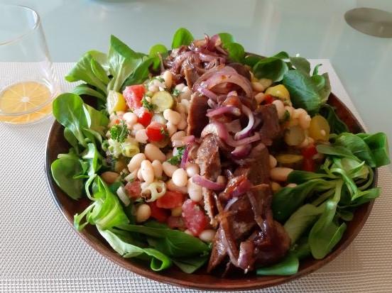 Zomerse witte bonensalade met augurk uitjes braadworst en gebakken uien