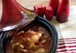 Tajine gevuld met poussin omgeven door zoet en pit