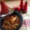 Tajine gevuld met poussin omgeven door zoet en pit