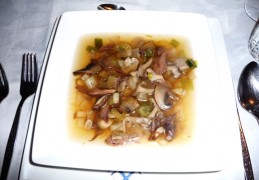 Heldere duivenbouillon met paddenstoelen garnituur