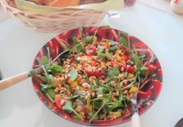 Courgettesalade met tomaatjes, paprika, rucola en pijnboompitten