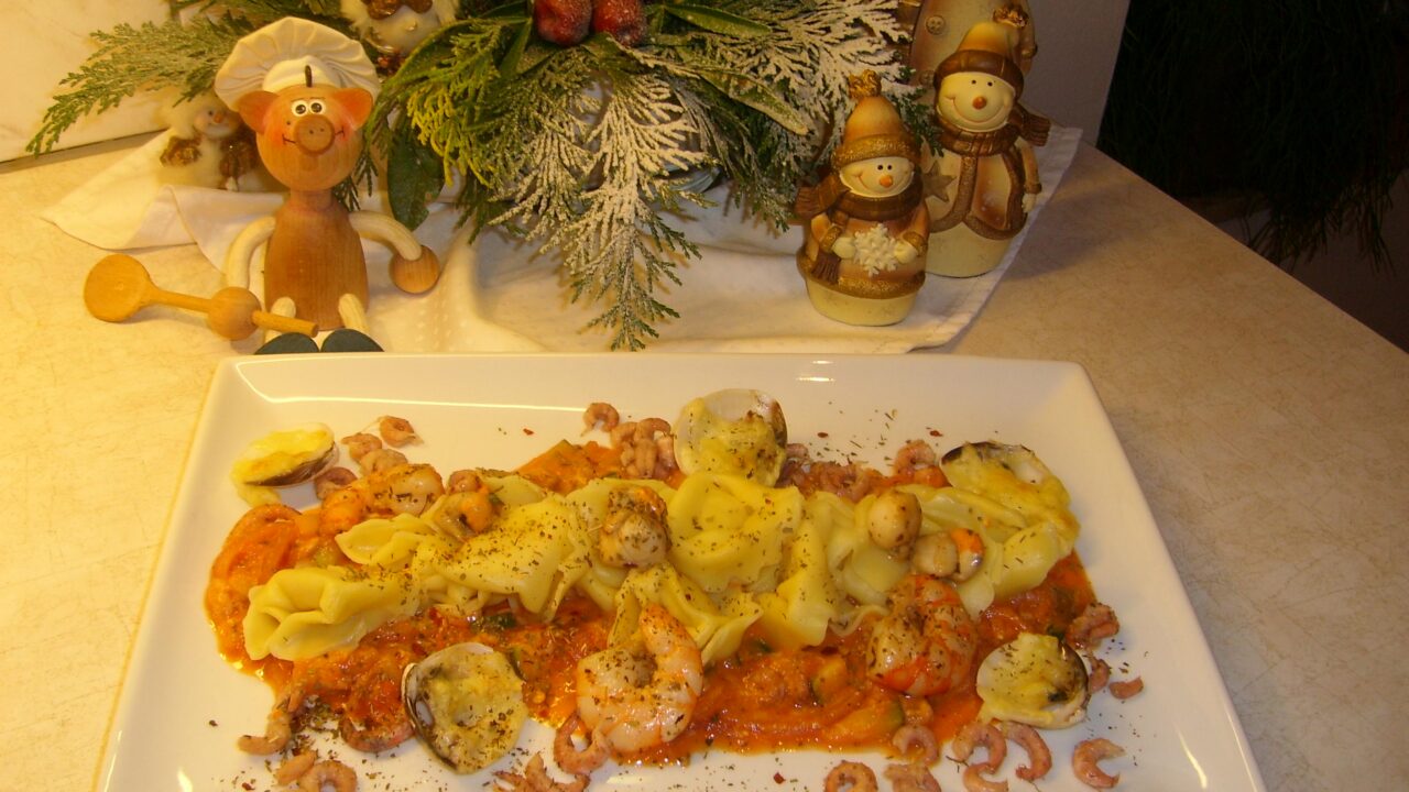 Tortellini gevuld met gorgonzola en ricota vergezeld van zeevruchten badend in een romig tomatensausje