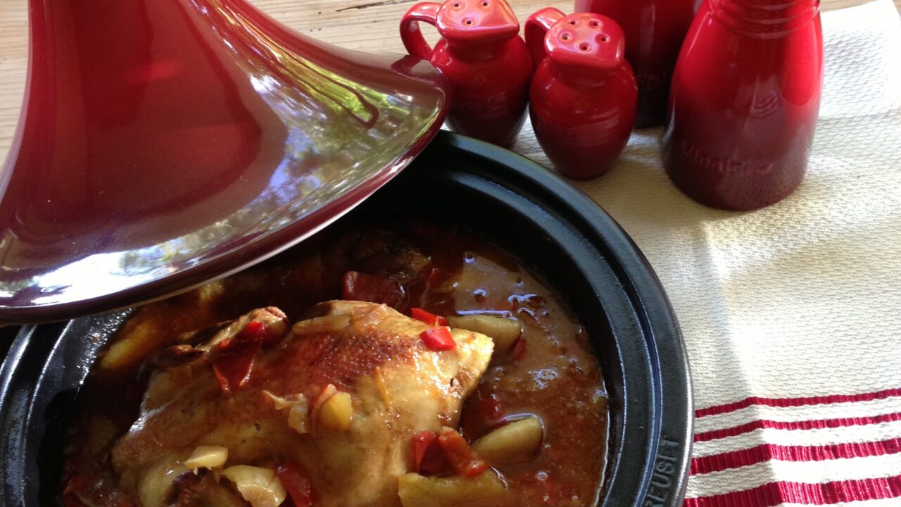 Tajine gevuld met poussin omgeven door zoet en pit