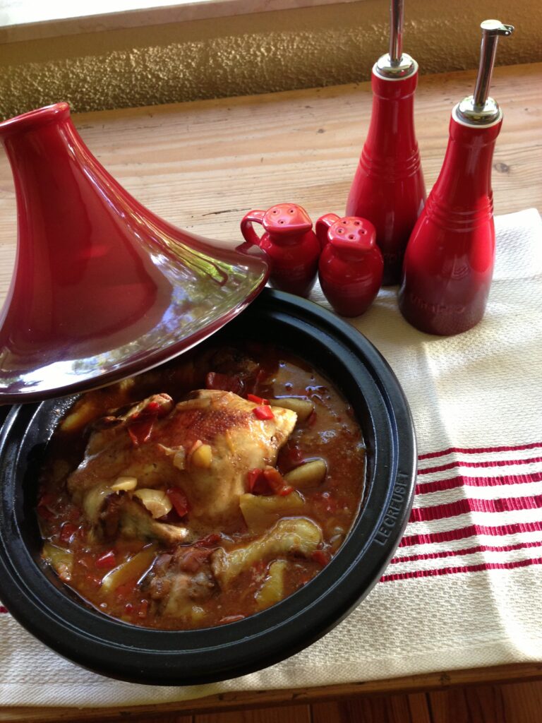 Tajine gevuld met poussin omgeven door zoet en pit