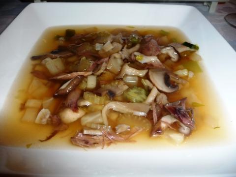 Heldere duivenbouillon met paddenstoelen garnituur