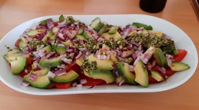 Avocado-tomatensalade met pesto en rode ui