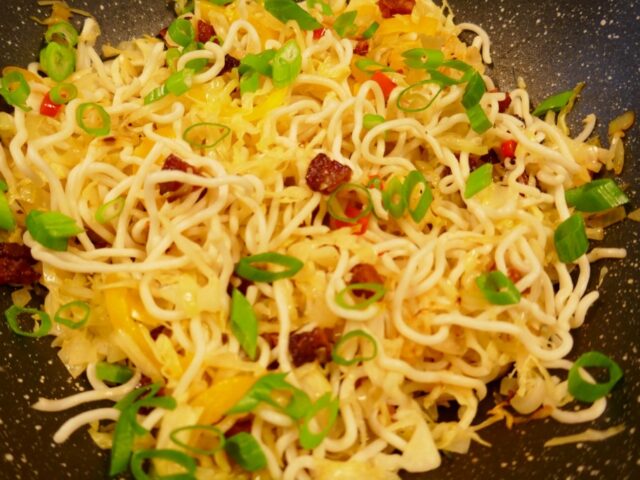 Spitskool met noedels uit de wok en een Spaans tintje.