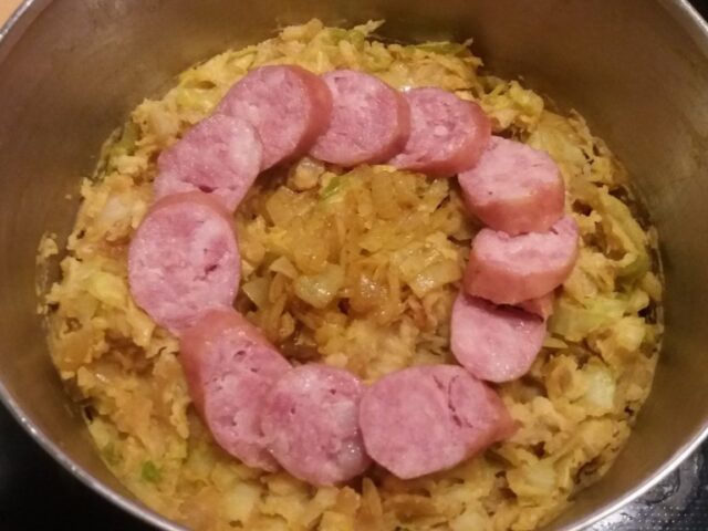 Stamppot pittige spitskool met kerrieuitjes en rookworst