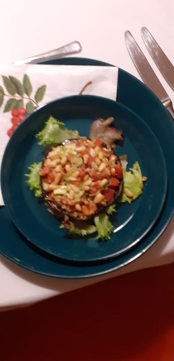 Portobello gevuld met mozarella, tomaat, pesto en pijnboompitten