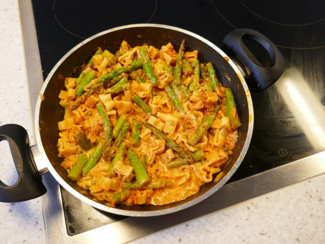 Groene asperges pasta met tuinerwtjes in een romige saus