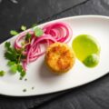 Kroketje van kabeljauwbrandade, gemarineerde rode ui en emulsie van peterselie
