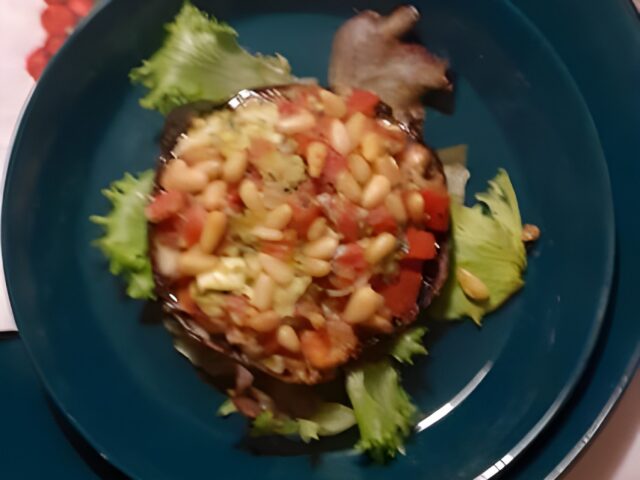 Portobello gevuld met mozarella, tomaat, pesto en pijnboompitten