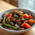 RUNDVLEES MET TOMAAT EN PAPRIKA IN ZWARTE BONENSAU