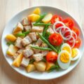 Salade met tonijn, aardappel, bonen, tomaat en ui