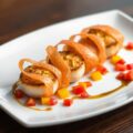 Scallops wrapped in gravadlax with mango slices.