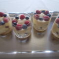 Trifle met mango frambozen en blauwe bessen in een glaasje