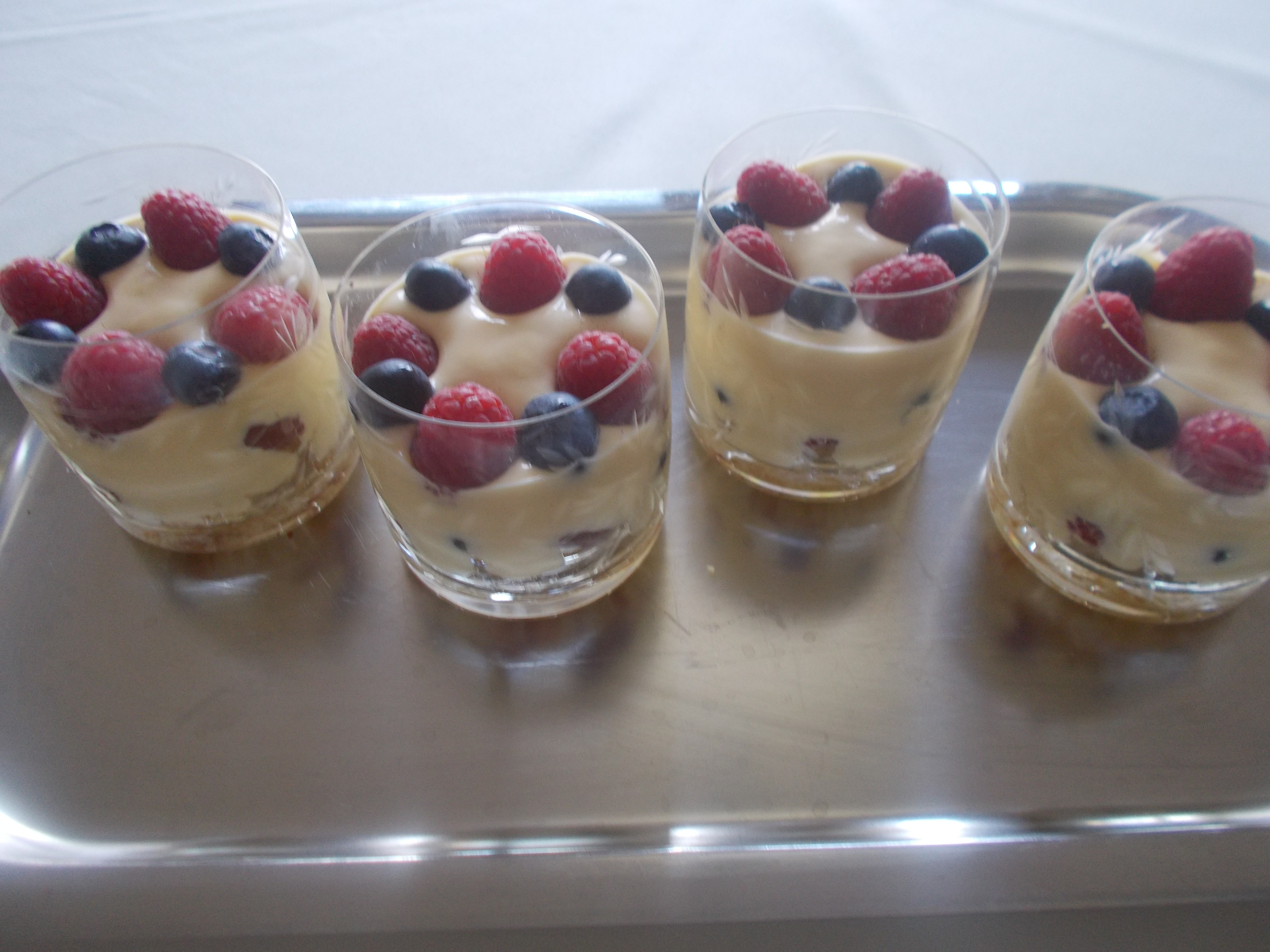 Trifle met mango frambozen en blauwe bessen in een glaasje