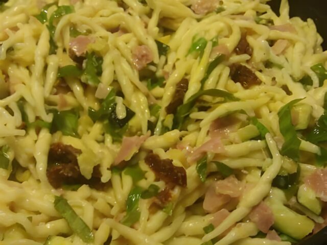 Trofie met ham, courgette, gedroogde tomaten en basilicum