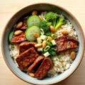 Aziatische bowl met runderfiletlapjes, zoetzure komkommer, broccolirijst en cashewnoten