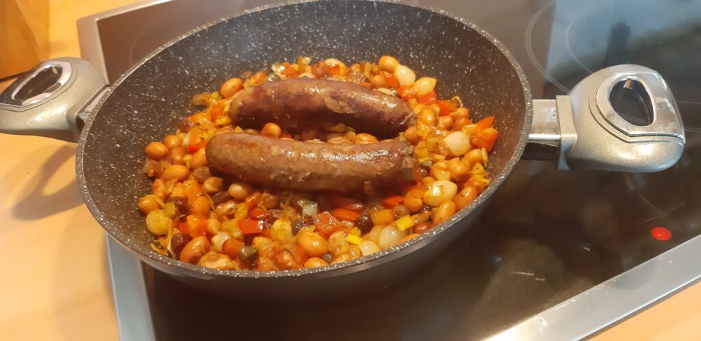 Bruine bonenschotel met saucijzen en uitjes Monegask