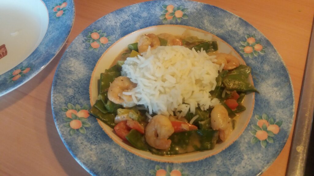 Curry met garnalen, peultjes, paprika en lente-uitjes. Lekker met rijst.