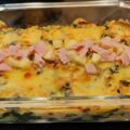 Gegratineerde ovenschotel van verse spinazie met aardappel, reepjes ham en blokjes kaas