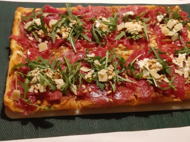 Gemakkelijke plaattaart van bladerdeeg met carpaccio, rucola en truffeltapenade