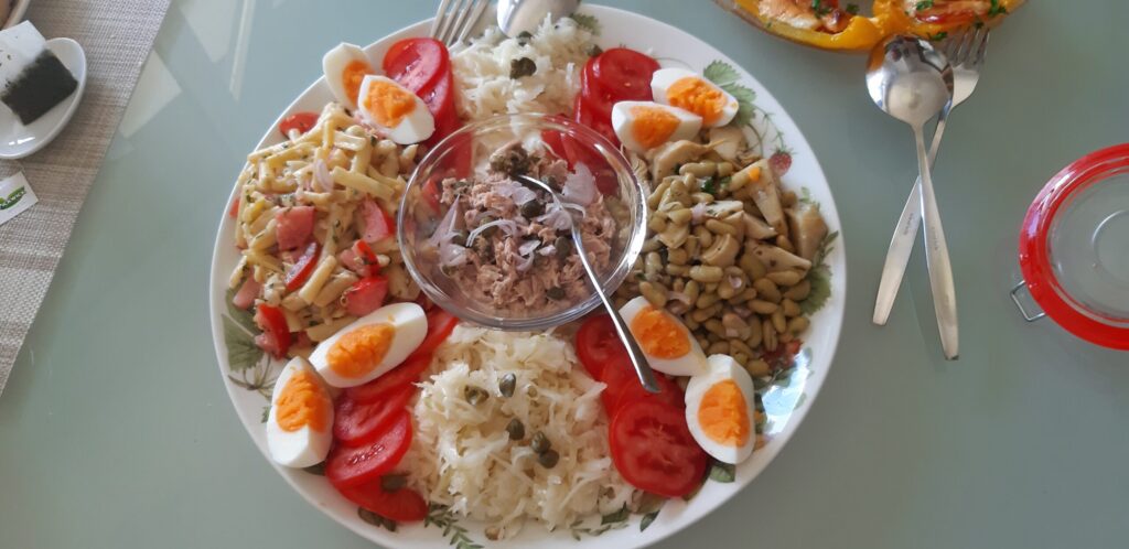 Gemengde lunchsalade met tonijn, witte kool-salade, boterbonen en flageolets met artisjokharten.