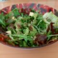 Gemengde rucola salade met witte kaasblokjes, gedroogde tomaten en olijven