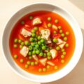 Heldere tomatenbouillon met doperwtjes en kalkoen