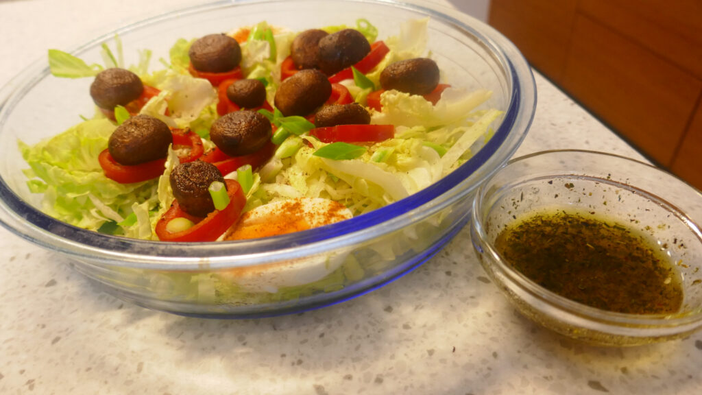 IJsbergsla met gebakken champignons , ei en puntpaprika