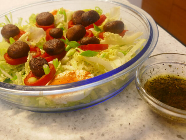 IJsbergsla met gebakken champignons , ei en puntpaprika