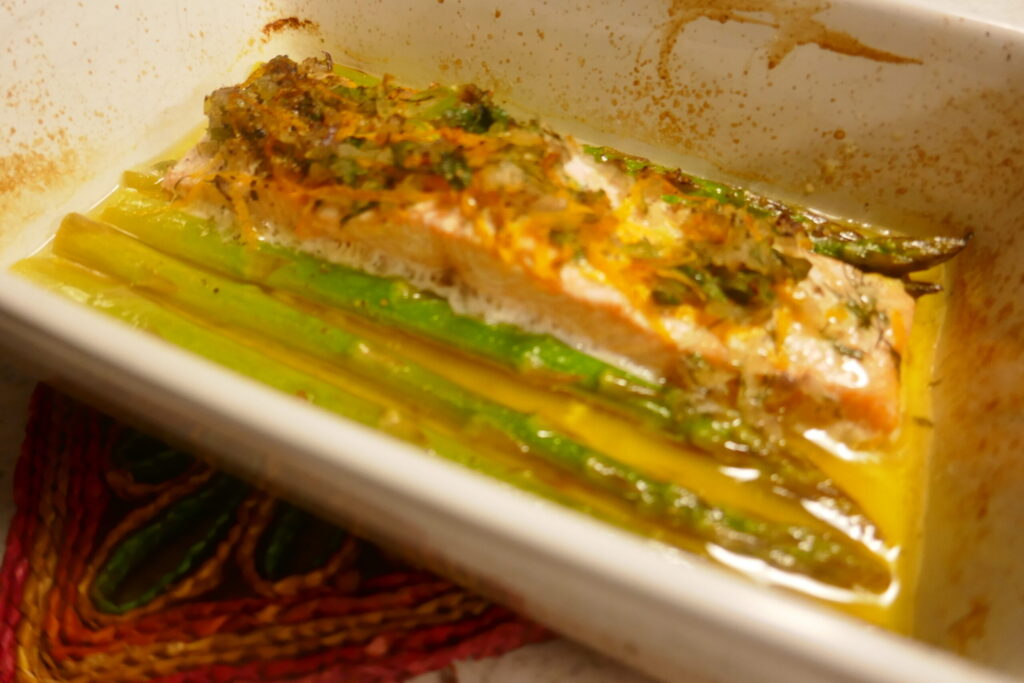 In sinaasappel gemarineerde zalm met een kruidentopping en groene asperges uit de oven