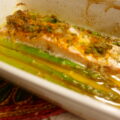 In sinaasappel gemarineerde zalm met een kruidentopping en groene asperges uit de oven