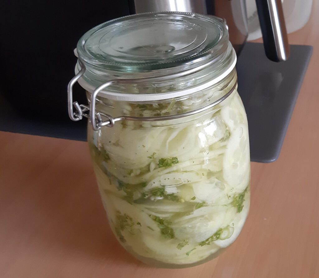 Ingelegde zoetzure komkommer met lente-uitjes en peterselie