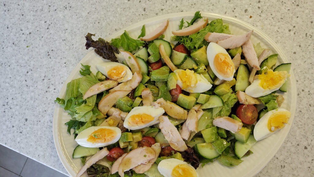 Maaltijdsalade met gerookte kip, avocado en een eitje