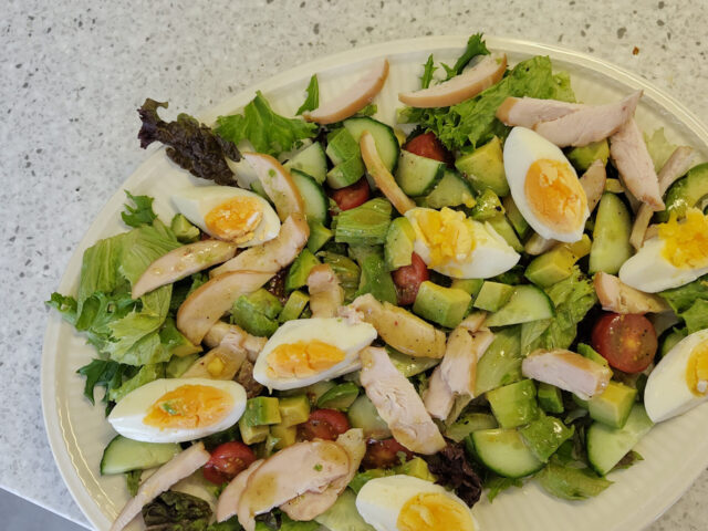 Maaltijdsalade met gerookte kip, avocado en een eitje
