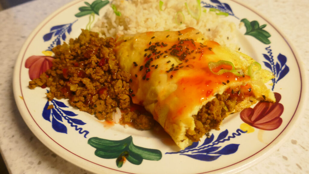 Met kerriegehakt gevulde omelet, ijsbergsla en rijst