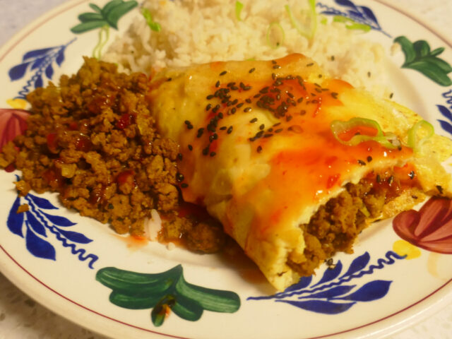 Met kerriegehakt gevulde omelet, ijsbergsla en rijst
