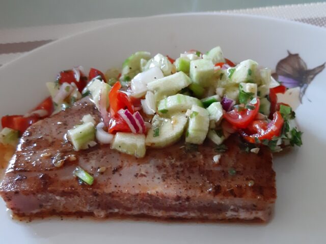 Gemarineerde tonijnsteak, gegrild en opgediend met frisse salsa van komkommer, tomaat en rode ui