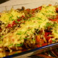 Ovenschotel met geraspte aardappel, champignons, paprika en getopt met kaas