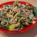 Romaine sla met gemarineerde artisjokharten, olijven, kaasblokjes en pijnboompitten