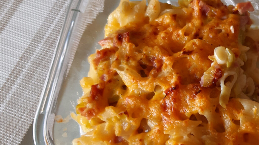 Romige pastaschotel met veel prei, ham en geraspte kaas