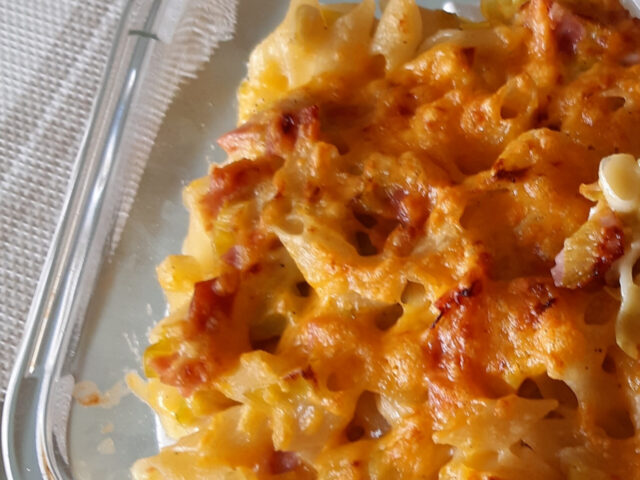 Romige pastaschotel met veel prei, ham en geraspte kaas
