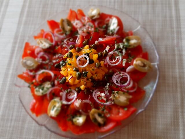 Spaanse tomaten/paprikasalade met rode ui, kappertjes en gevulde olijven