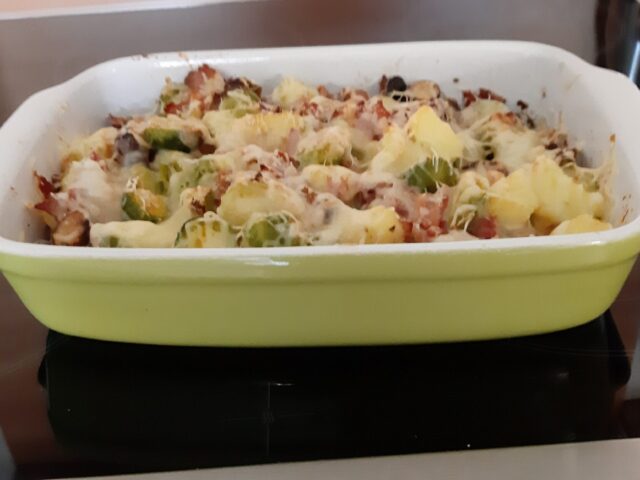 Spruitjesschotel met aardappelblokjes, pancetta, champignons en kaas