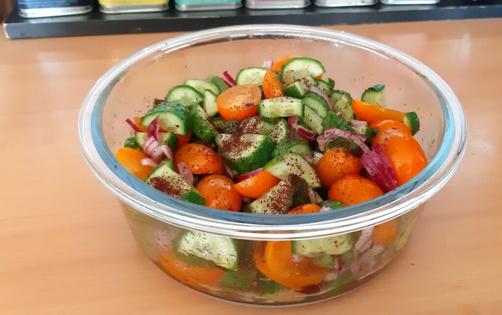 Tomaten-komkommersalade met rode ui en sumak