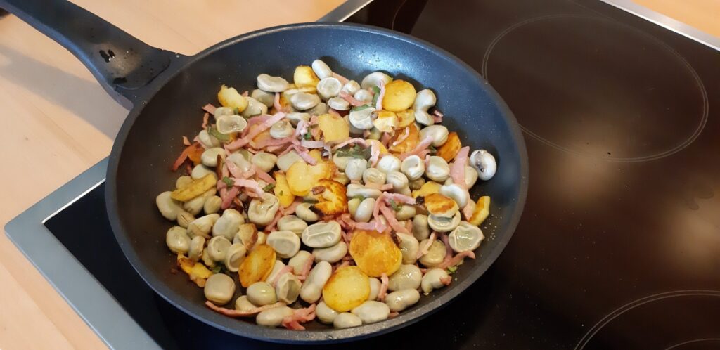Tuinbonenpannetje met salie, gebakken aardappelschijfjes en hamreepjes