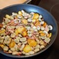 Tuinbonenpannetje met salie, gebakken aardappelschijfjes en hamreepjes